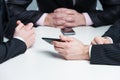 Hands of three businessmen in a meeting