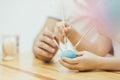 Hands with three painbrushes colouring blue easter egg. Happy family. Easter mood. Focus on the egg.