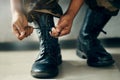 Hands tie shoes, closeup and soldier in army getting ready to start war, battle or fight. Boots, man tying laces in Royalty Free Stock Photo