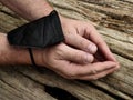 hands tied with FPP-2 medical mask on a wooden surface