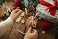 Hands tied ribbon on christmas oatmeal cookies on rustic wooden table with stylish festive decorations. Atmospheric christmas