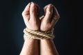 Hands tied with rope on black background Royalty Free Stock Photo