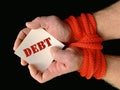 Hands tied with a rope, on a black background. Tied hands are holding a note with the inscription. Concept: loan, debt, help Royalty Free Stock Photo