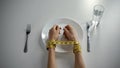 Hands tied with tapeline on empty plate, girl obsessed with counting calories Royalty Free Stock Photo