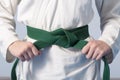 Hands tightening green belt on a teenage dressed in kimono Royalty Free Stock Photo