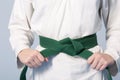 Hands tightening green belt on a teenage dressed in kimono Royalty Free Stock Photo