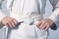 Hands tightening white belt on a teenage dressed in kimono Royalty Free Stock Photo
