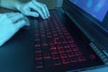 Hands tiping on laptop keyboard at night in display blue light Royalty Free Stock Photo