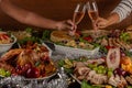 Hands toasting sparkling wine at Christmas dinner, festive table.