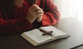 Hands together in prayer to God along with the bible In the Christian concept and religion, woman pray in the Bible on the wooden Royalty Free Stock Photo