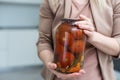 hands tomatoes in a jar on a white background isolation