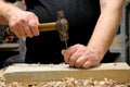 Hands with a tool on the background of a carpentry workshop.