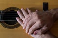 Hands on top of a classical guitar