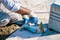 Hands of a Turkish pavement construction worker installing tiles with a trowel and a hammer Royalty Free Stock Photo