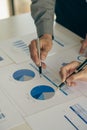 Hands of two businessmen holding pens analyzing charts, financial graphs and accounting documents. The information displayed calcu Royalty Free Stock Photo