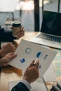 Hands of two businessmen holding pens analyzing charts, financial graphs and accounting documents. The information displayed calcu Royalty Free Stock Photo