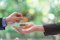 Hands of two businessmen are trading coin of ethereum. A symbolic coins of ethereum. electronic money exchange,