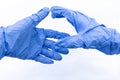 Hands of two people in blue sterile gloves greet on a white background. The concept of virus protection. Selective focus Royalty Free Stock Photo