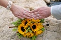 Hands with two white gold wedding rings on sunflower bouquet Royalty Free Stock Photo