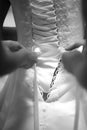 Hands tying a wedding dress