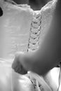 Hands tying a white laced wedding dress, detail of brideÃÂ´s back