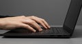Hands typing on a black laptop keyboard. The laptop is open and Royalty Free Stock Photo
