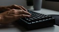 Hands typing on a black mechanical keyboard with illuminated keys, suggesting