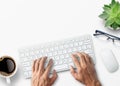 Hands typing on computer keyboard over white office desk table with cup of coffee and supplies Royalty Free Stock Photo