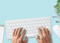 Hands typing on computer keyboard over white office desk table with cup of coffee and supplies Royalty Free Stock Photo