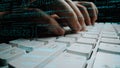 Hands Typing on a Computer Keyboard Surrounded by Code and Programming Concepts in a Dark Environment xenic Royalty Free Stock Photo