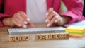 Hands typing on keyboard and data science text on cubes