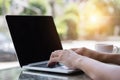 Hands typing on laptop in coffee shop