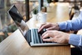 Hands typing on laptop computer keyboard, person writing email or report document in cafe with coffee and wifi internet, casual Royalty Free Stock Photo