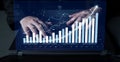 Hands Typing on Laptop with Digital Charts and Graphs Displayed Representing Financial Growth and Data Analysis in Royalty Free Stock Photo
