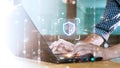 Hands typing on a laptop with a digital shield and lock icon, symbolizing cybersecurity. Surrounded by binary code and glowing
