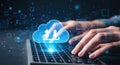 Hands typing on a laptop with a glowing blue cloud icon symbolizing data transfer and cloud computing technology Royalty Free Stock Photo