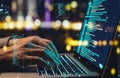 Hands typing on a laptop with glowing digital code and city lights in the background Royalty Free Stock Photo