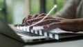 Hands Typing on Laptop with Graph Overlay Illustrating Growth and Data Analysis in Modern Workspace Environment Copula Royalty Free Stock Photo