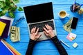 hands typing on laptop keyboard on blue wooden table with stationery Royalty Free Stock Photo