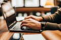 Hands typing on a laptop keyboard in a cozy workspace Royalty Free Stock Photo