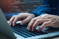 Hands typing on laptop keyboard with digital code snippets, blurred background, HTML elements visible Royalty Free Stock Photo