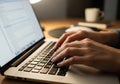 Hands typing on a laptop keyboard, focused on coding or text editing. The screen displays an Royalty Free Stock Photo