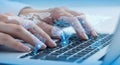 Hands typing on a laptop keyboard with glowing digital data overlay symbolizing technology and innovation Royalty Free Stock Photo