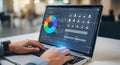 Person working on a laptop displaying a colorful data visualization and user interface design Royalty Free Stock Photo