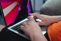 Hands typing on a laptop. Unknown person with orange shirt Royalty Free Stock Photo
