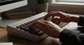 Hands typing on a mechanical keyboard with brown keys, positioned on a woode