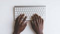 Hands typing on a modern computer keyboard on a white surface Royalty Free Stock Photo