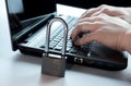 Hands typing over the keyboard on laptop. Padlock on laptop computer security