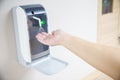 hands under the automatic alcohol dispenser.