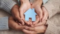The hands of unity holding a blue house symbolizing community and togetherness. AI generated image Royalty Free Stock Photo